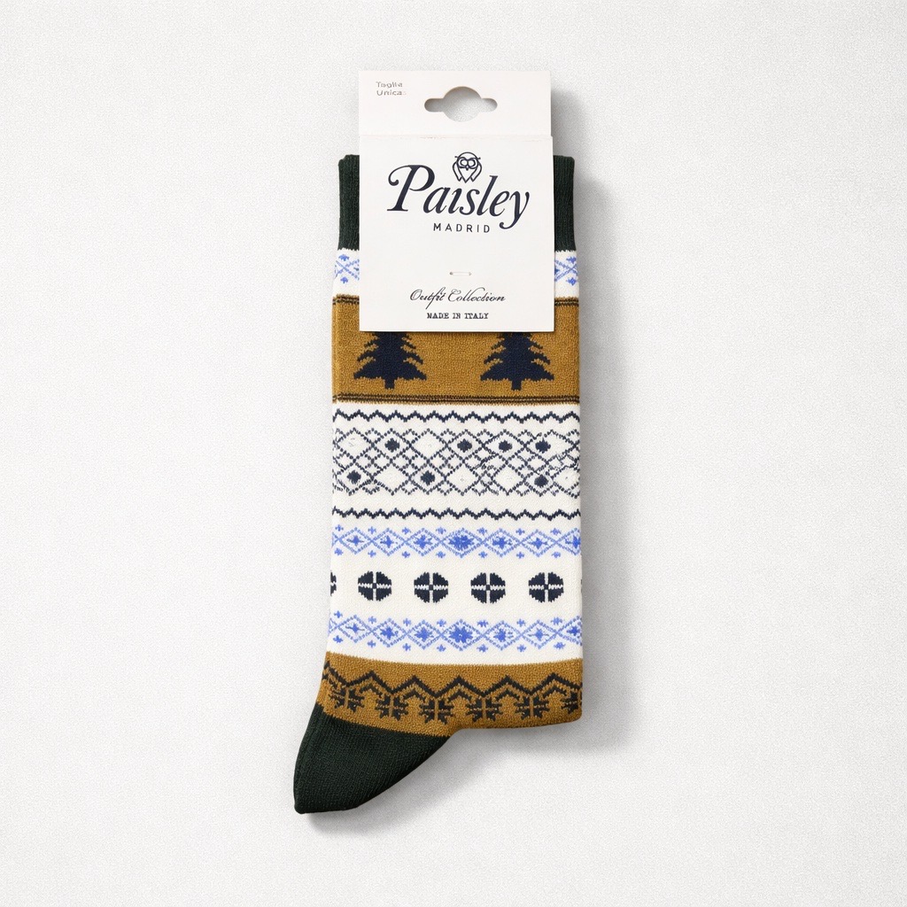Un único calcetín Paisley Madrid con un estampado de inspiración nórdica en blanco, azul, negro y amarillo mostaza, con diseños de árboles y geométricos. El calcetín está doblado con una etiqueta de la marca en la parte superior.
