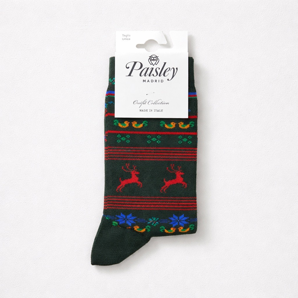 Un par de calcetines verde oscuro con renos rojos, copos de nieve azules y dibujos de colores, empaquetados con una etiqueta blanca de Paisley Madrid en la que se lee Craft Collection Made in Italy.
