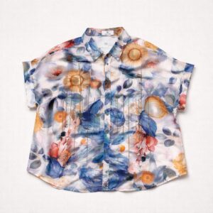 Blusa de manga corta con un colorido estampado floral y de hojas en tonos azules, amarillos, naranjas y rosas