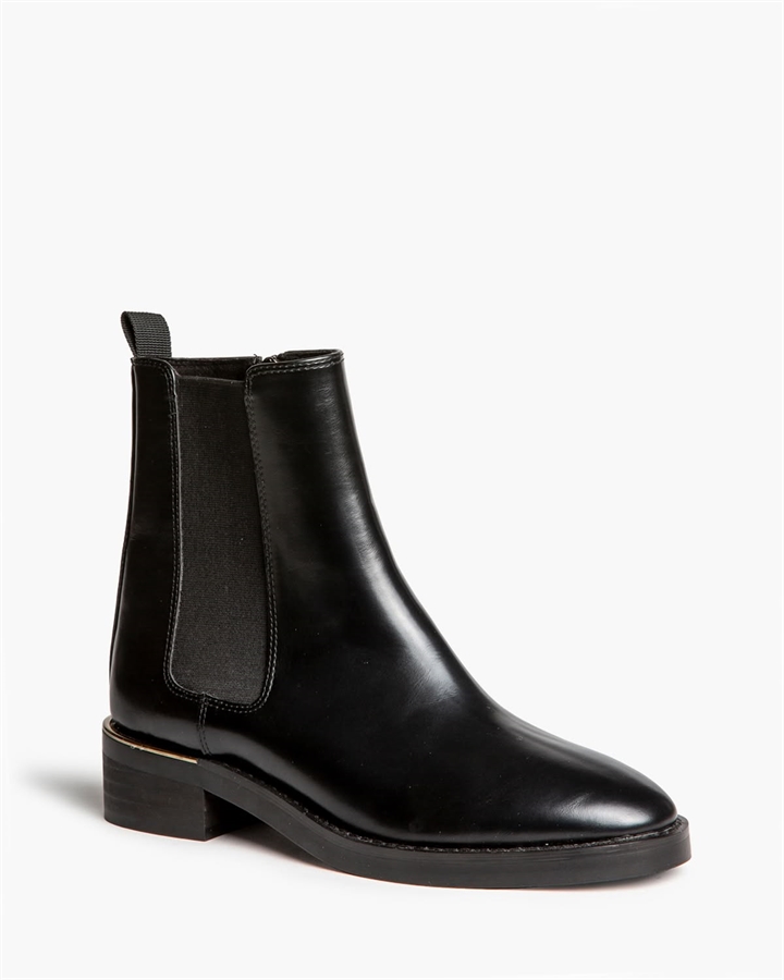 Botín Chelsea negro de mujer con elásticos laterales, tirador trasero y tacón bajo con detalle dorado, en Lybastore