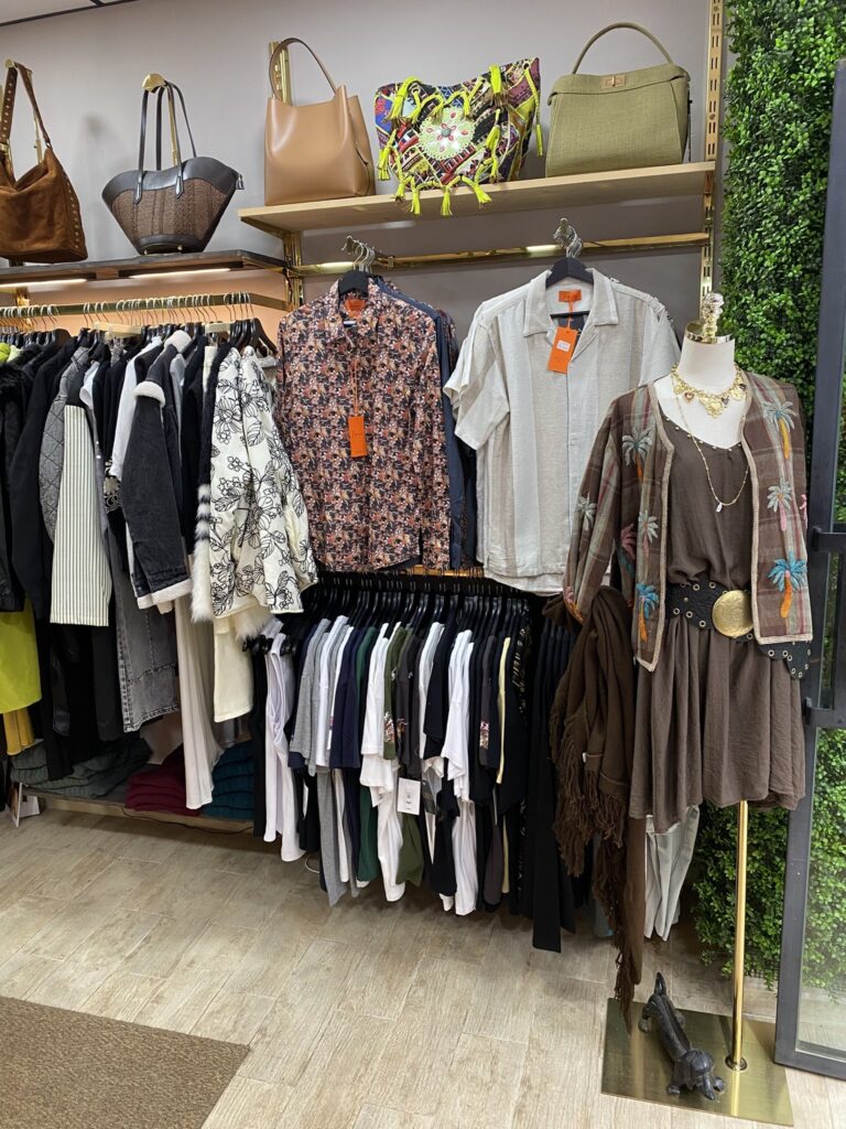 Camisas de hombre, bolsos y chaquetas en LYBA Store Rincón de LYBA Store con camisas de hombre, camisetas, chaquetas de mujer y bolsos en la estantería