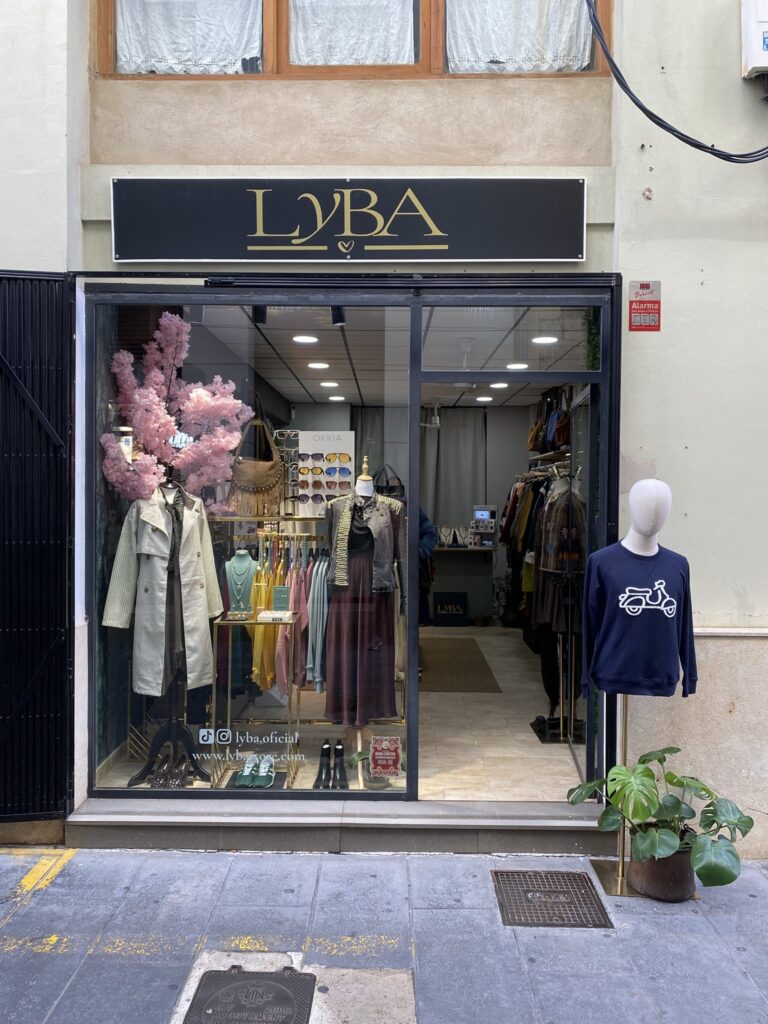 Fachada de LYBA Store en la calle Tapinería, Valencia Fachada de la tienda LYBA Store en la calle Tapinería de Valencia, con escaparate de otoño y maniquí con sudadera Vespa en la puerta